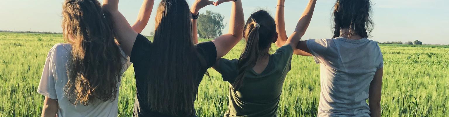 Youth in a rolling field holding hands
